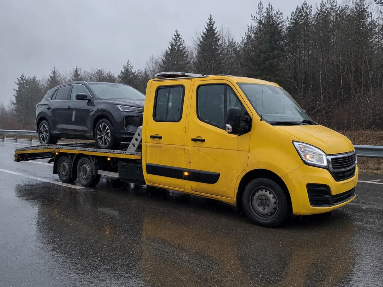 Holowanie srebrnego SUV-a na lawecie w deszczu – Mysłowice